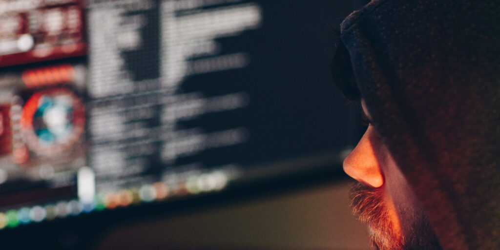 man wearing hoodie looking at computer