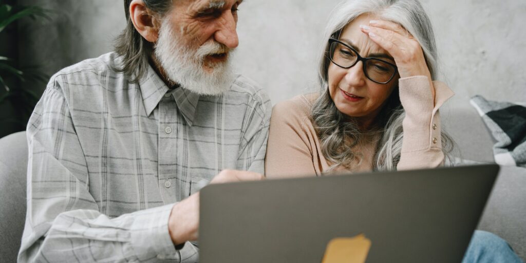 man and woman looking perplexed at a laptop
