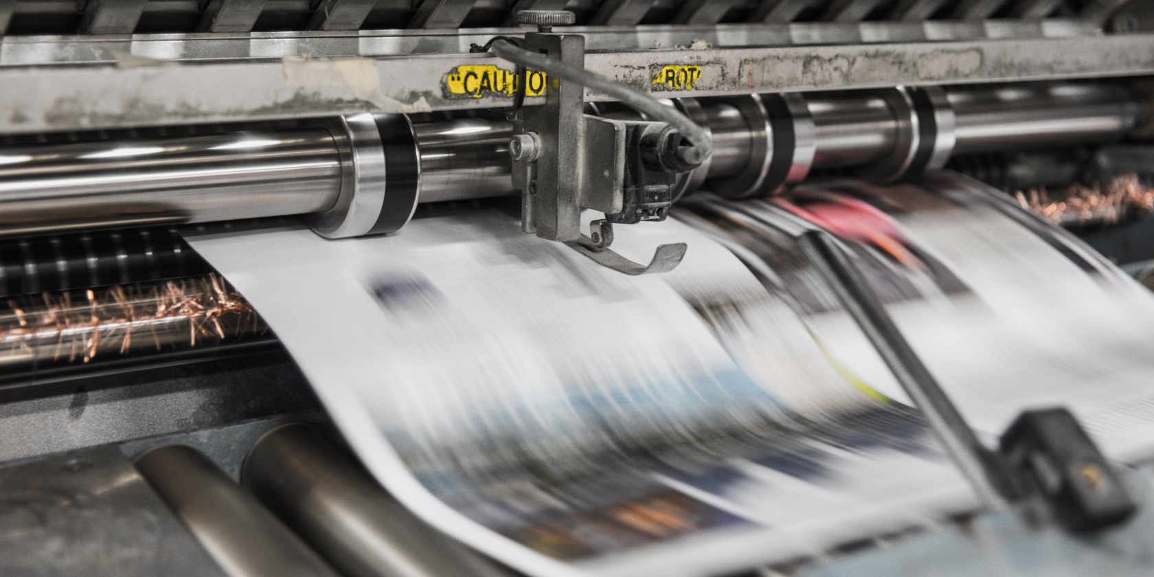 Blurred newspapers rolling off a printing press 