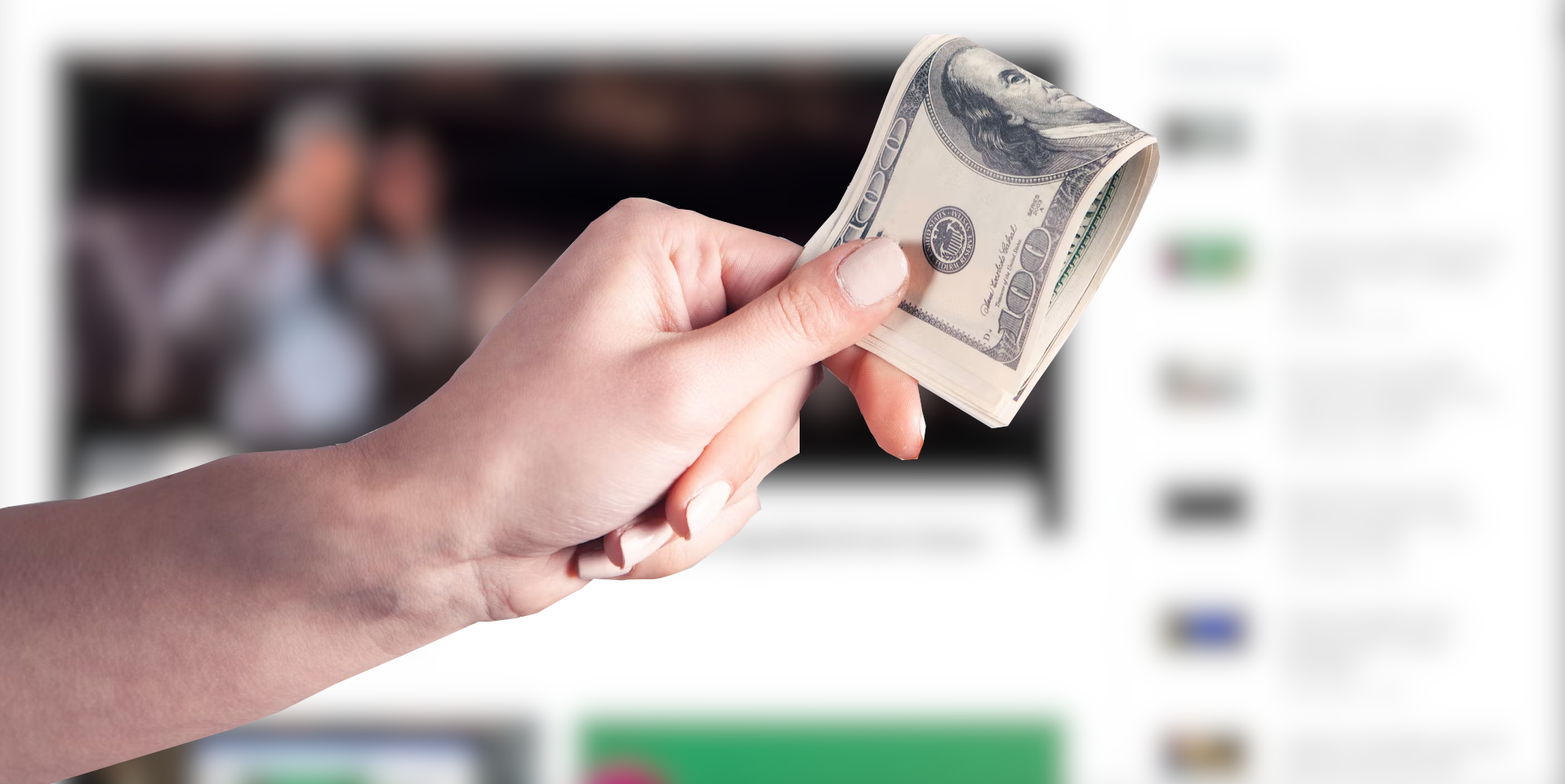 A hand holding folded money in front of a blurred web page