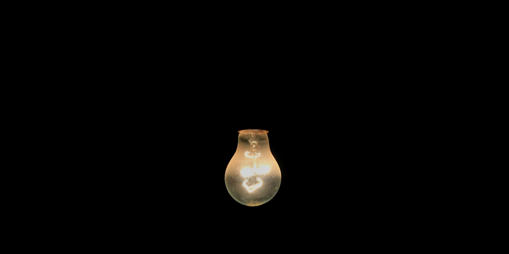 Incandescent lightbulb against a black background